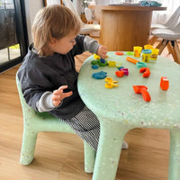 kid playing on mint confetti set
