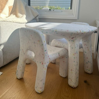 Children's table and chairs in a living room setting with a couch and window in the background.